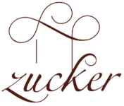 La palabra "zucker" está escrita en texto cursivo marrón con remolinos decorativos que se extienden desde la letra "z", lo que refleja la elegancia de la pastelería creativa y las delicias gourmet de catering.